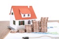 The East Asian old man is placing increasing dollar coins and a small house model beside him Royalty Free Stock Photo