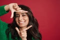 East asian woman wearing sweater smiling and making frame gesture