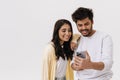 East asian young man and woman smiling and using cellphone together Royalty Free Stock Photo