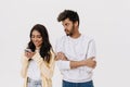 East asian young man and woman smiling and using cellphone together Royalty Free Stock Photo