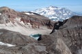 The east crater of Gorely volcano with blue acid lake covered partially with ice in august Royalty Free Stock Photo