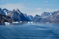 East Greenland coast with jagged mountains, icebergs and blue sea