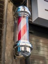 An East London barber shop pole in red & white spiral stripes.