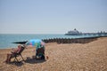 Holidaymakers with a colourful umbrella on the shingle beach Royalty Free Stock Photo
