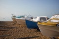 Four fishing boats moored on the shingle beach under a clear blue sky Royalty Free Stock Photo
