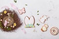 Easter aesthetics glazed cookies with nest decorations on white background flat lay.