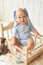 Easter Baby boy sitting on crib. Easter bunny. Children Protection Day. Happy childhood. Early child development. Educational