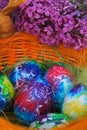 Easter background. Art decorated eggs with lilac and feather in basket