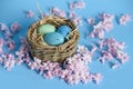 Easter background with blue Easter eggs in nest of spring flowers. Top view with copy space. Happy Easter Spring Festive greeting Royalty Free Stock Photo