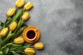 Easter background with blue, green eggs and a cup of tea in nest and yellow tulips. Top view with copy space Royalty Free Stock Photo