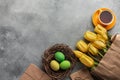 Easter background with blue, green eggs and a cup of tea in nest and yellow tulips. Top view with copy space Royalty Free Stock Photo