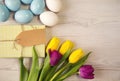 Easter background with blue and white eggs and purple and yellow tulips Royalty Free Stock Photo