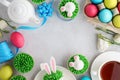 Easter background with bunny cupcakes, tea and painted eggs Royalty Free Stock Photo