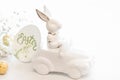 Easter background with a ceramic hare in the car and eggs on a white background, Royalty Free Stock Photo