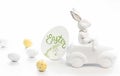 Easter background with a ceramic hare in the car and eggs on a white background, Royalty Free Stock Photo