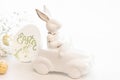 Easter background with a ceramic hare in the car and eggs on a white background, Royalty Free Stock Photo