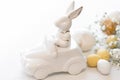 Easter background with a ceramic hare in the car and eggs on a white background, Royalty Free Stock Photo