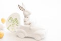 Easter background with a ceramic hare in the car and eggs on a white background, Royalty Free Stock Photo
