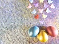 Easter background. Colored pearl eggs of gold, pink, coral, blue and turquoise on a halo background with a copy space