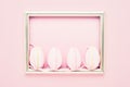 Easter background. Decorative pink Easter Eggs and tulip flowers on pink background. Top view, copy space. Easter celebration