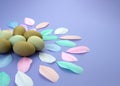 Easter background. Easter egg composition of olive eggs and pastel color feathers on violet background