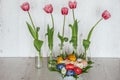 Easter Background with easter eggs and pink tulips in glass bottles on light wooden background Royalty Free Stock Photo