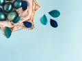Easter background with eggs decorated in blue, turquoise and gold in nest with feathers. Copy space. Royalty Free Stock Photo