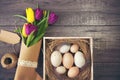 Easter background with eggs in nest and purple and yellow tulips Royalty Free Stock Photo