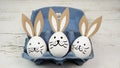 Easter background greeting card -Close-up from white painted eggs and easter bunny in blue egg carton on rustic white vintage Royalty Free Stock Photo