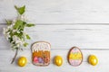 Easter background of laid out Apple tree twig, yellow eggs, gingerbreads on white wooden table