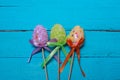 Easter background. Multicolored decorated easter eggs, multi-colored powder on a turquoise background. Free space Royalty Free Stock Photo