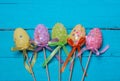 Easter background. Multicolored decorated easter eggs, multi-colored powder on a turquoise background. Free space