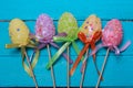Easter background. Multicolored decorated easter eggs, multi-colored powder on a turquoise background. Free space