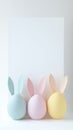 Easter background of three pastel eggs with paper bunny ears. Space for text.