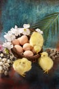 Easter background with a wicker basket full of eggs and yellow chickens Royalty Free Stock Photo