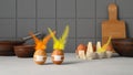 Two brown easter rabbits made from eggs wearing protective face masks and feather ears on the kitchen table