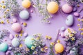 Colorful easter eggs and flowers on purple background, top view