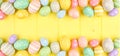 Easter banner with double border of pastel Easter Eggs over a yellow wood background with copy space Royalty Free Stock Photo