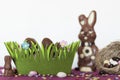 Easter basket with chocolate eggs, chocolate bunny, nest with almonds and sweets on table Royalty Free Stock Photo