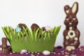 Easter basket with chocolate eggs, chocolate bunny and sweets on table Royalty Free Stock Photo