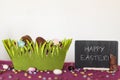 Easter basket with chocolate eggs  chocolate bunny missing a bite and blackboard with Happy Easter text Royalty Free Stock Photo