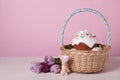 Easter basket with painted eggs, tasty cake, flowers and rabbit figure on white wooden table. Space for text Royalty Free Stock Photo