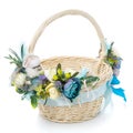 Easter basket on white background. Decorated with flowers in blue and a small decorative sheep. Ribbons and lace Royalty Free Stock Photo