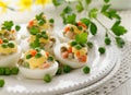 Easter boiled eggs stuffed with traditional vegetable salad with mayonnaise served on a white plate