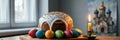 Easter bread with colorful eggs and lit candle by window Royalty Free Stock Photo