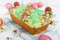 Easter bread kulich with glaze, colorful sugar sprinkles. Colored painted eggs. Royalty Free Stock Photo