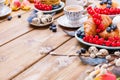 Easter breakfast flat lay with fresh coffee, berries and pastries , orange tulips, croissants with bacon and various sweets , Royalty Free Stock Photo