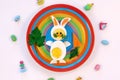 Easter breakfast idea for kids. Bunny rabbit made of boiled eggs on multicolored plate, white background, top view Royalty Free Stock Photo