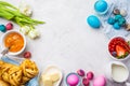 Easter Breakfast table, top view. Colored eggs, flowers, buns, milk, juice and jam, white background Royalty Free Stock Photo