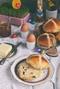 Easter breakfast with traditional hot cross buns, jam, butter and egg. Holiday still life. Festive table place setting decoration Royalty Free Stock Photo